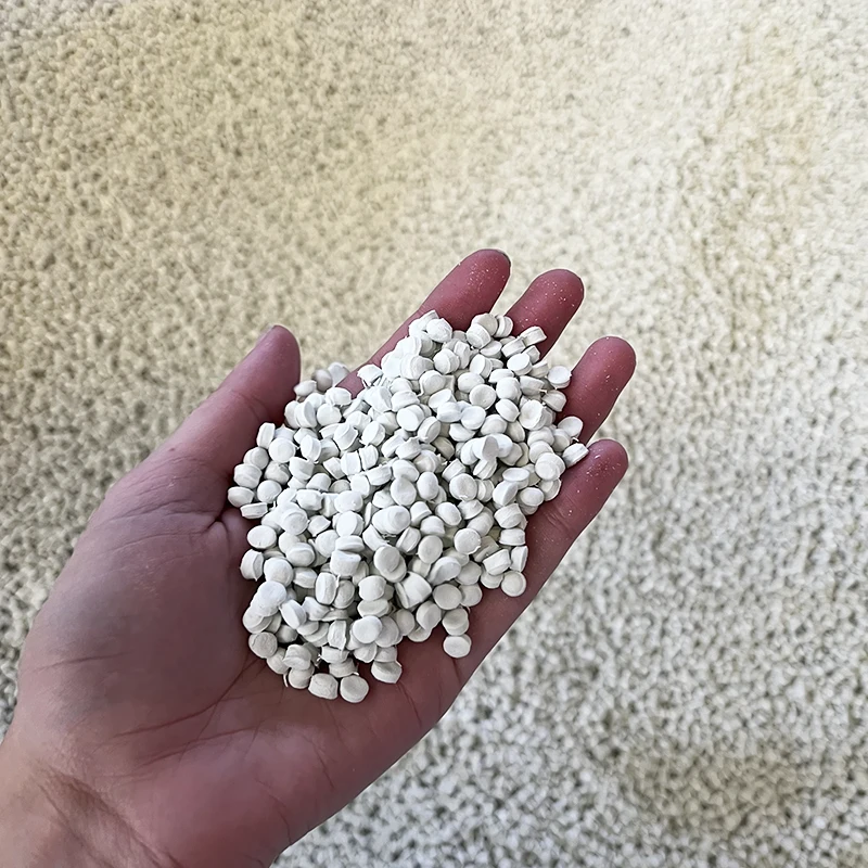 Mão segurando grânulos de composto de EVA, matéria-prima de alta qualidade utilizada na fabricação de solados.